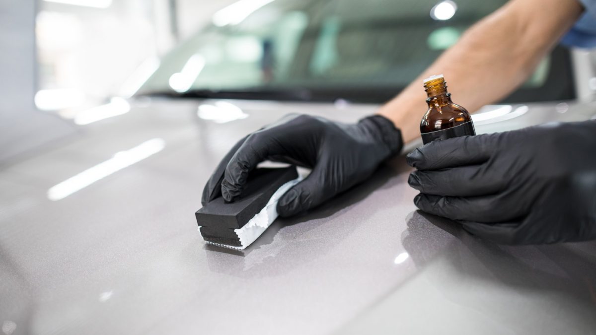 A person applying ceramic coating on car